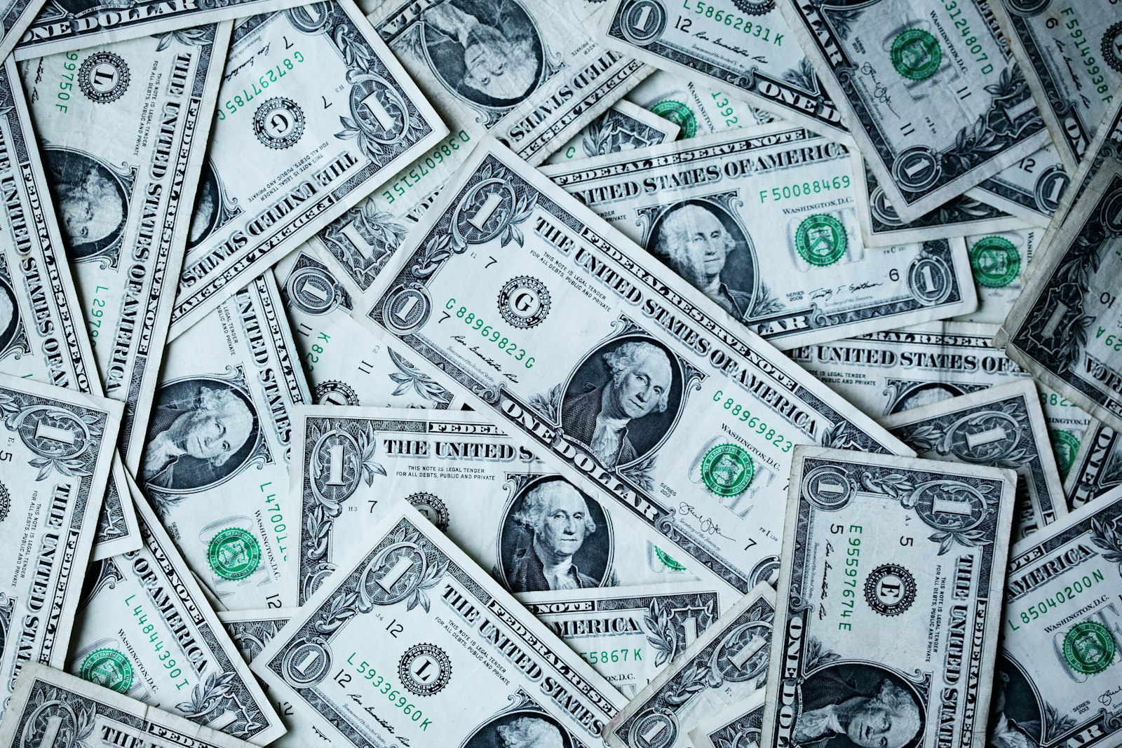 Close-up of overlapping United States one-dollar banknotes filling the frame